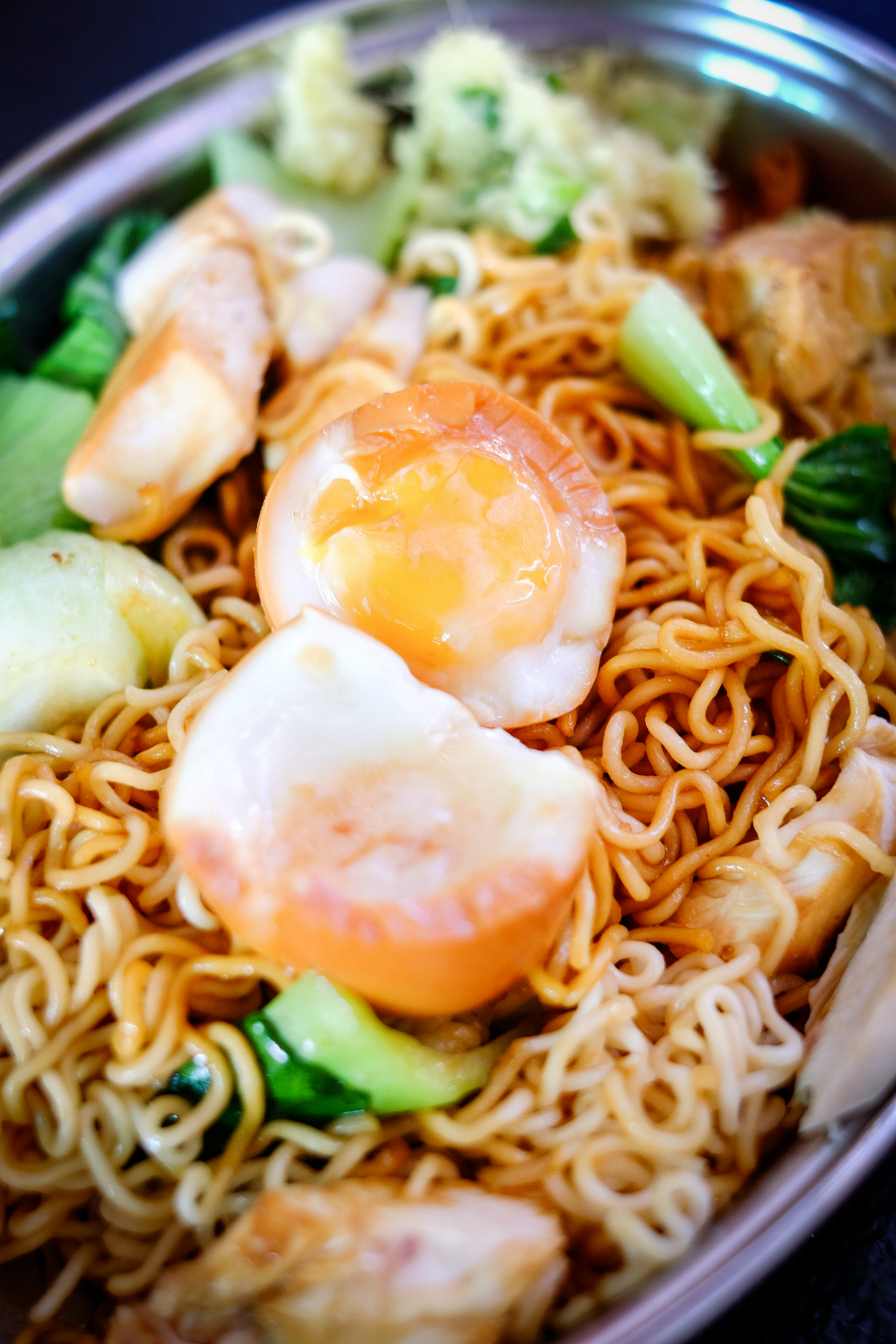 Uncle Chicken Rice: instant noodles cooked till al dente, topped with soy sauce chicken, a lava egg, luncheon meat, fresh greens and their signature ginger and scallion dip