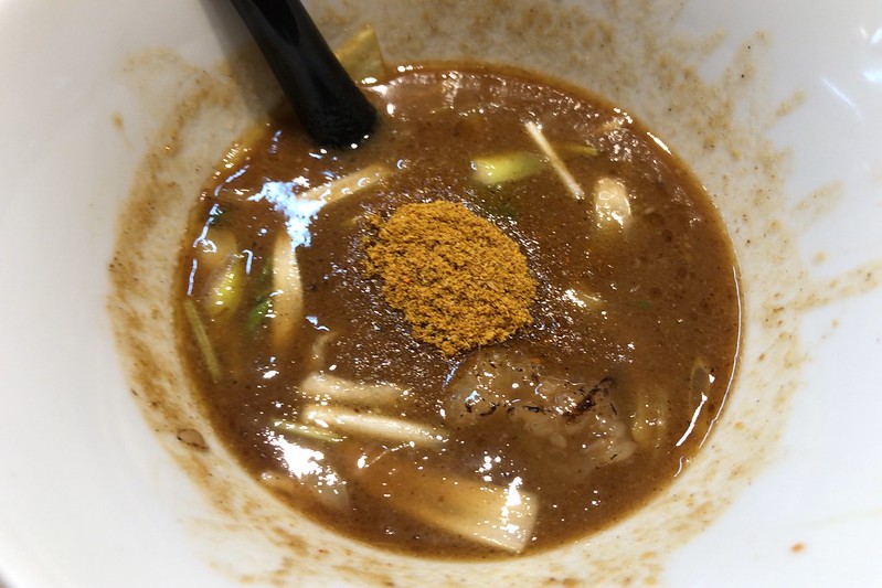 池袋西口ガガナラーメン炙りホルモンつけ麺のスープにカレー魚粉を入れて味変