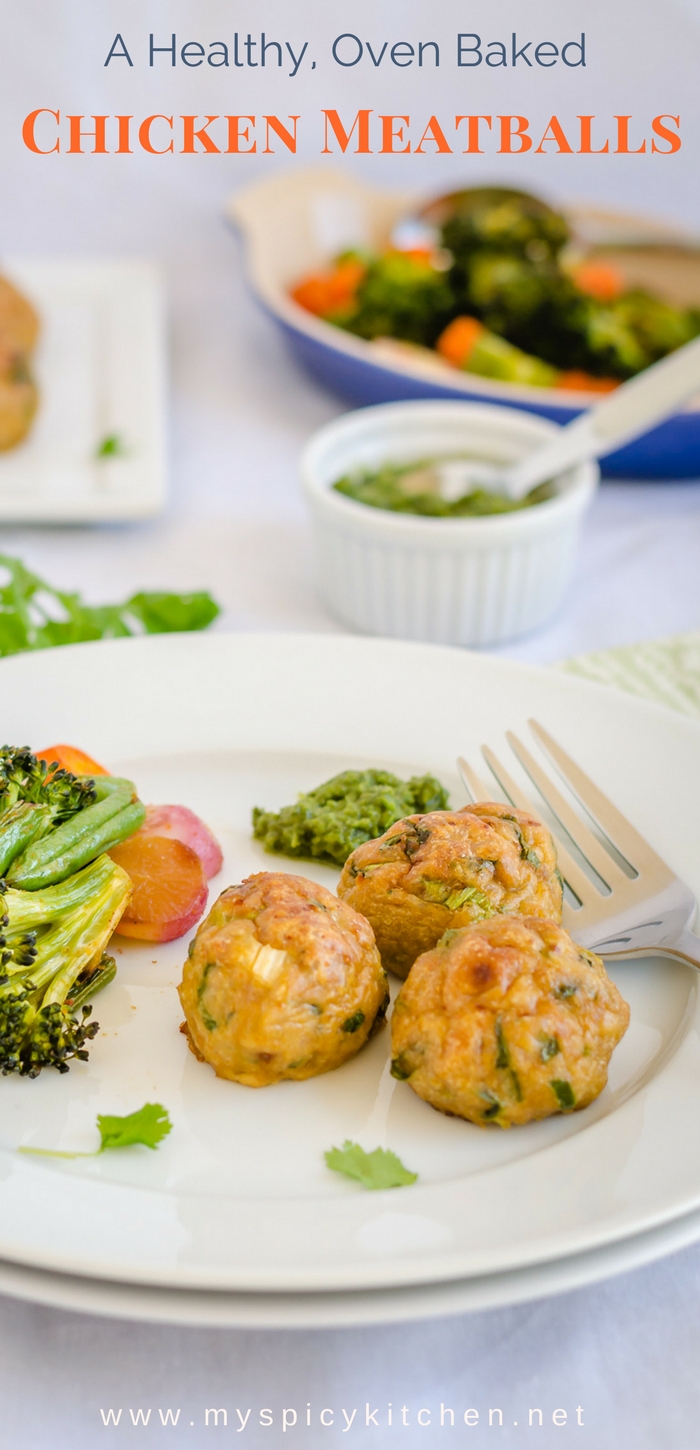 A plate of healthy, baked chicken meatballs seasoned with Indian spices and served with baked vegetables. 