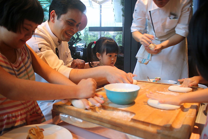 Chefs showing kids how to make pizza