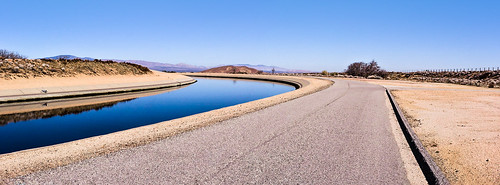 antelopevalley california fairmont blue brown californiaaqueduct flowingwater joelach mohavedesert mojavedesert river runningwater stream gravitydriven sharpturn paved road bluesky