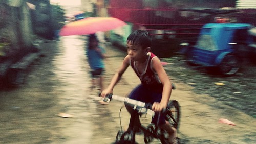 thephilippines manila bagongsilang rain storm typhoon color horizontal hot 33c boy bike bicycle acid