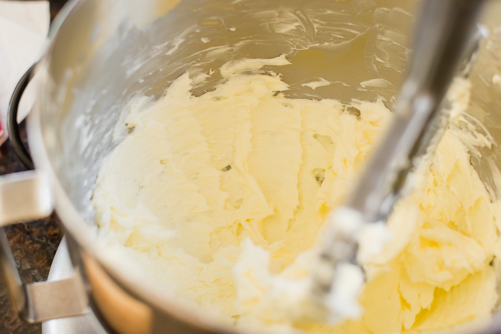 Begin making Italian wedding cookies by creaming together butter and powdered sugar until blended and creamy.