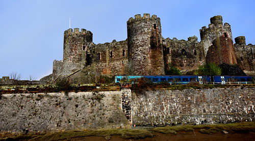 interesting ajourneythroughtime conwy northwales conwycastle castle ancientmonument train arrivatrains cadw conwytown village walls stone estuary water riverconwy landscape outdoor turrets stonework masonry windows trees grasses persective bluesky bridge historic historicmonument sand riverbank 08022018 afternoon february dof pov best timetravel graphic art artistic winter wideangle sigma f35 textures cymruambyth 5328°n3825556°w poster petersroberts flickr nikond7200 towers monumental medievil fortification fotografíavisión photographyvision
