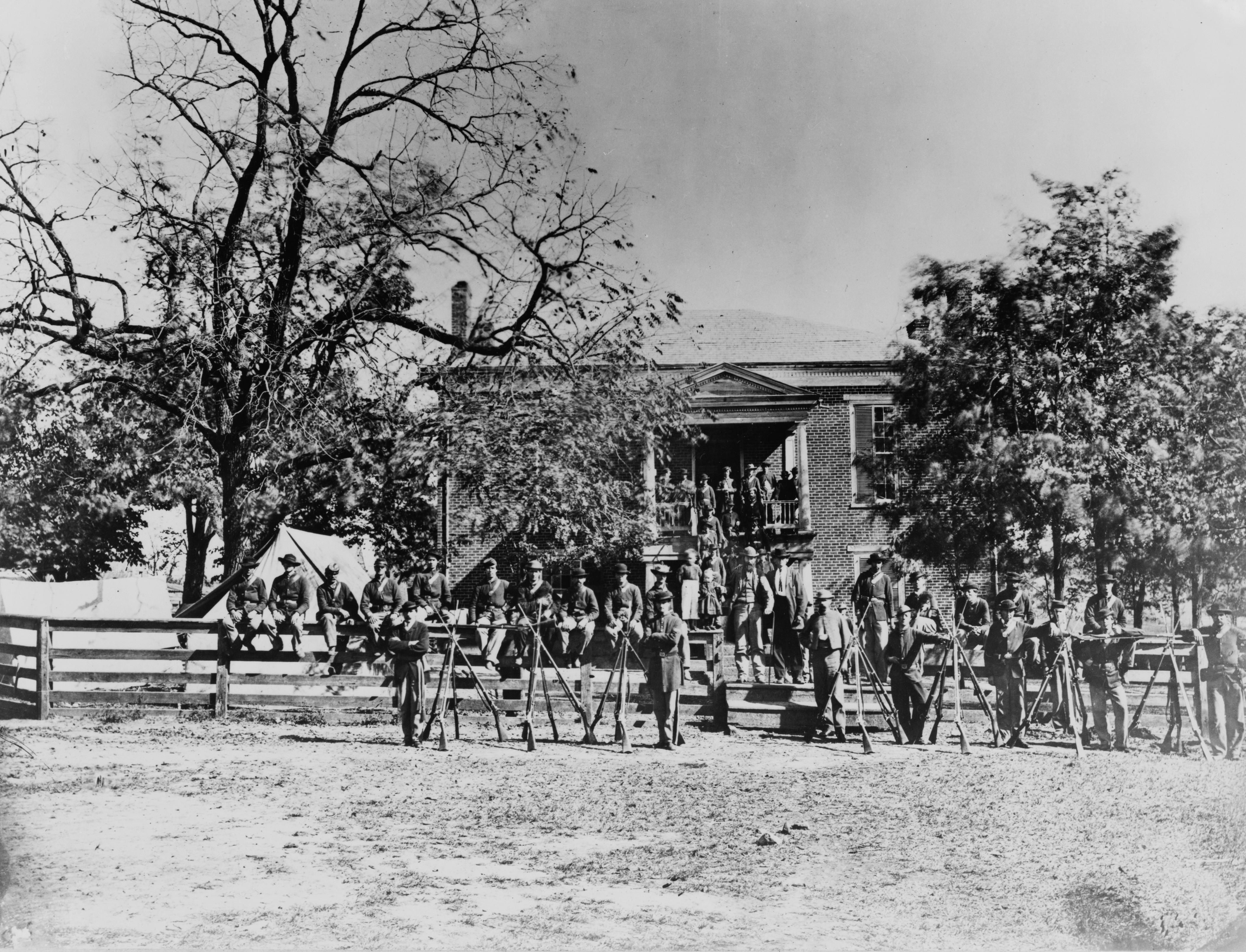 Photograph of the exterior, main facade, of Appomattox Court House, Appomattox, Virginia with Union soldiers posing in front of the building in April 1865.
