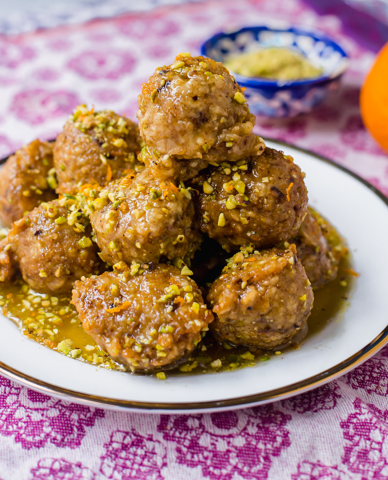 Baklava Bimuelos are a Sephardic Matzo Donuts that are gently fried and doused in a rose water syrup and garnished with pistachios.