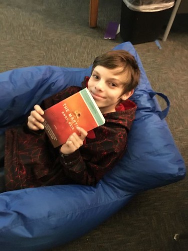 boy holds up new book he is reading