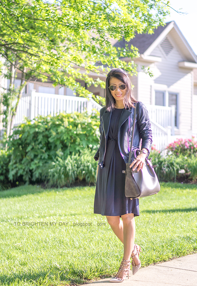 black leather jacket, navy twisted front knit dress, gray tote, studded nude pumps, two tone watch