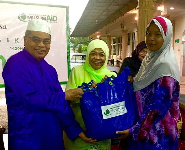 L-R_Muslim Aid Malaysia Chairperson, Wan Rusli Wan Muda and Datuk Rosnah Majid representing Coca-Cola hands over food basket to communities in need