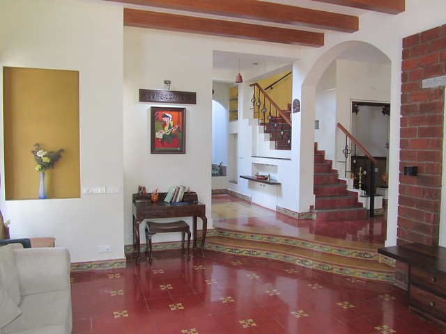 A traditional South Indian home with niches athangudi floor tiles, Jaipur blue tile and exposed brick wall.