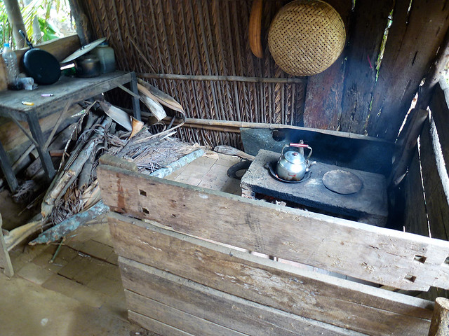 Simple home kitchen in a Vietnamese household with an open fire and several rough timber bench tops