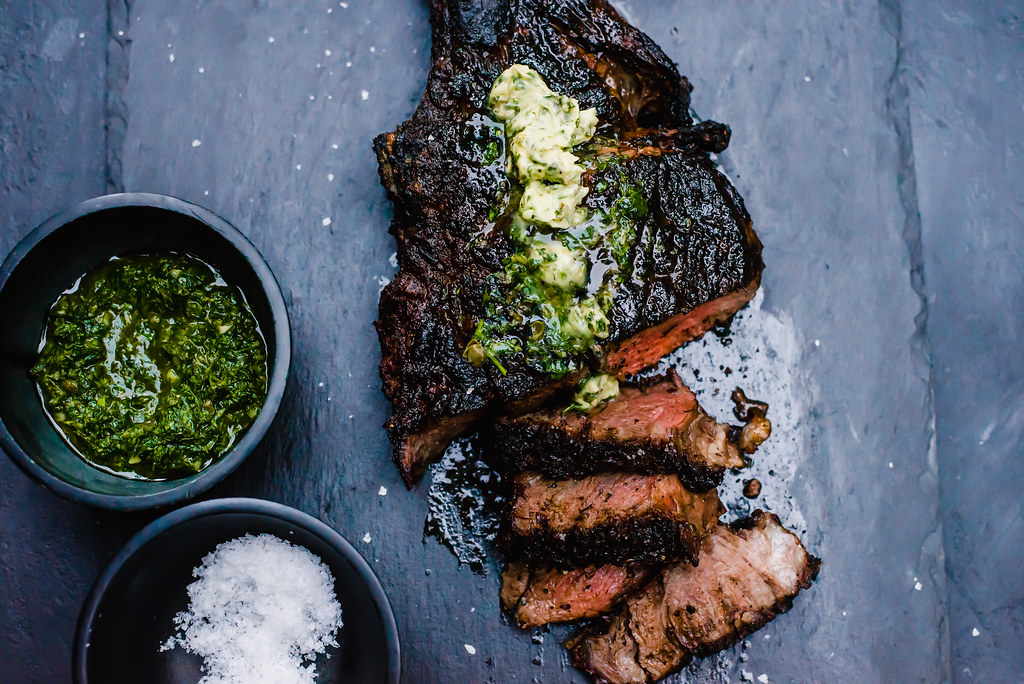 Grilled tomahawk steak served with a bright chimichurri compound butter.