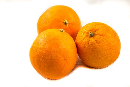 Three oranges on paper with white background