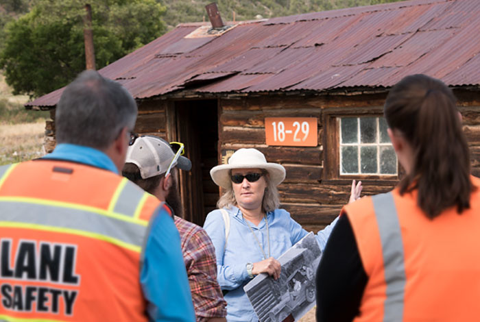 Lab historian stands in front of Pond Cabin on a tour.
